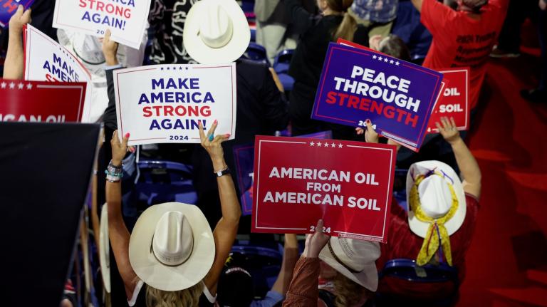 People hold signs that read
